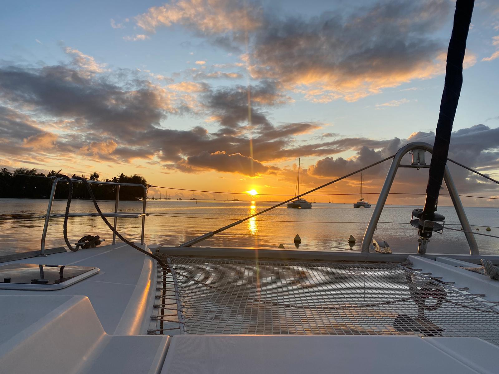 Catamaran anchored in Tahiti lagoon at sunset