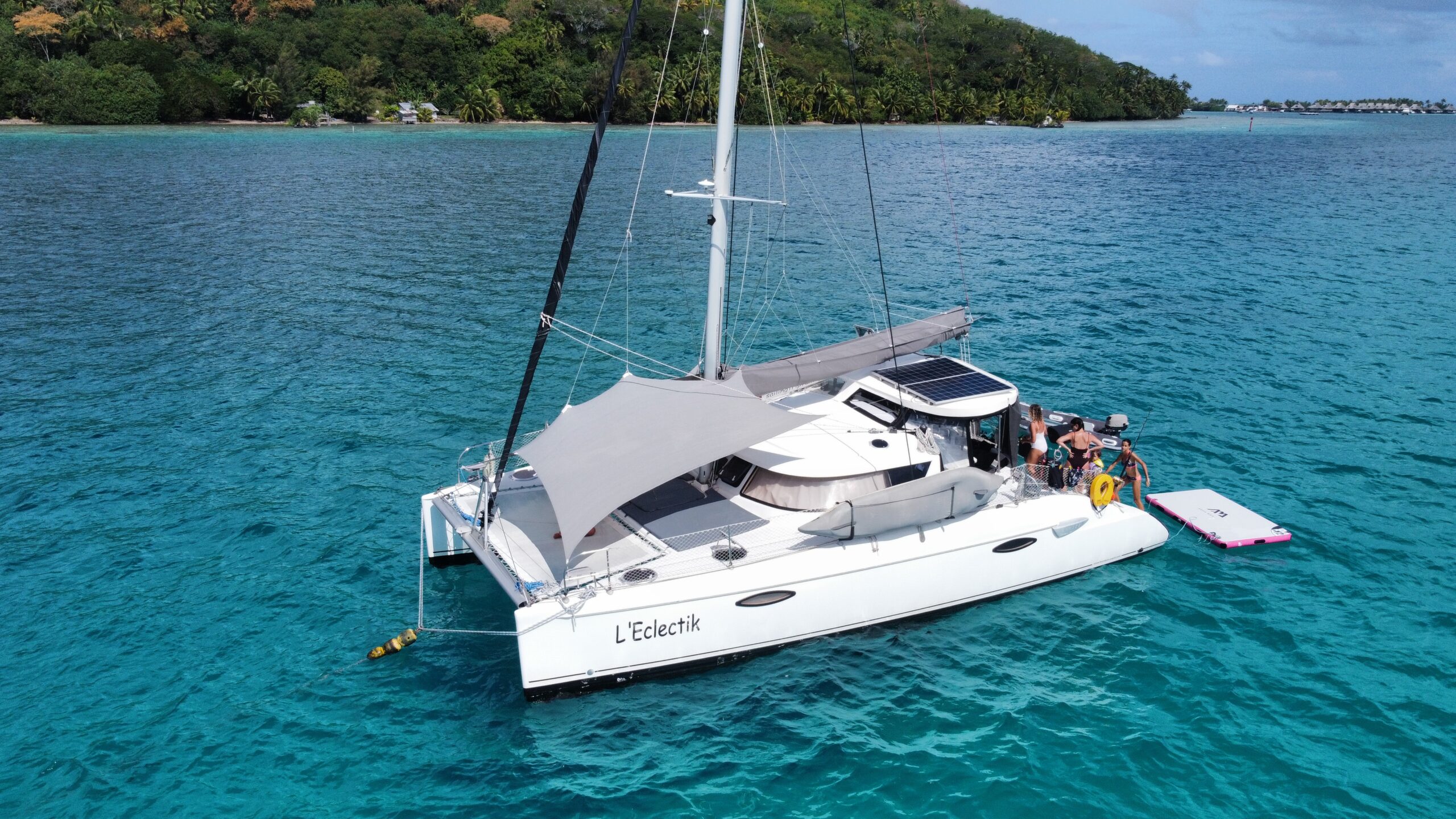 Family-friendly catamaran anchored near a Tahitian motu