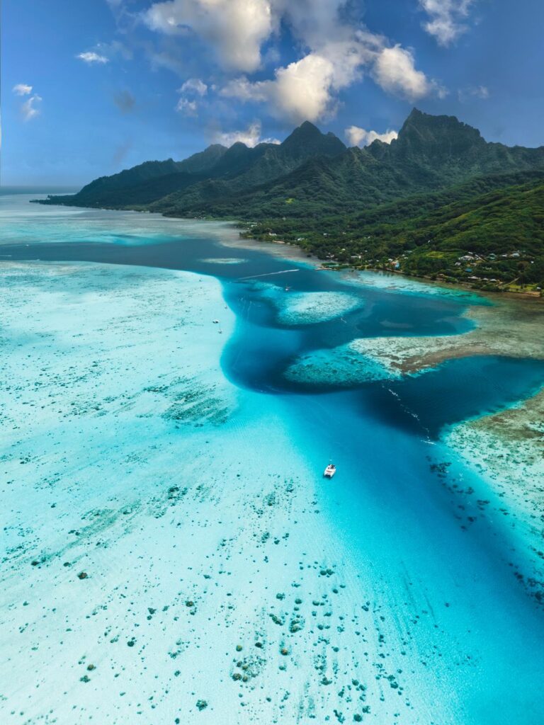 Catamaran anchored in the isolated turquoise lagoon of Raiatea during a private sailing cruise.