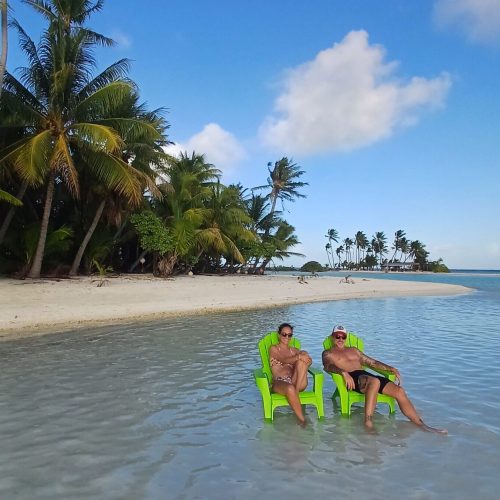 Couple sitting hand-in-hand on the beach