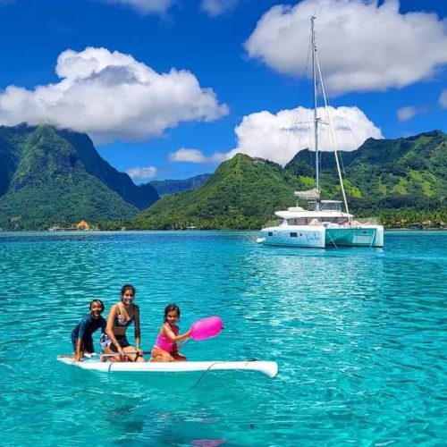 Family Paddleboarding near a private catamaran