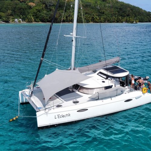Private catamaran anchored in turquoise Tahiti lagoon